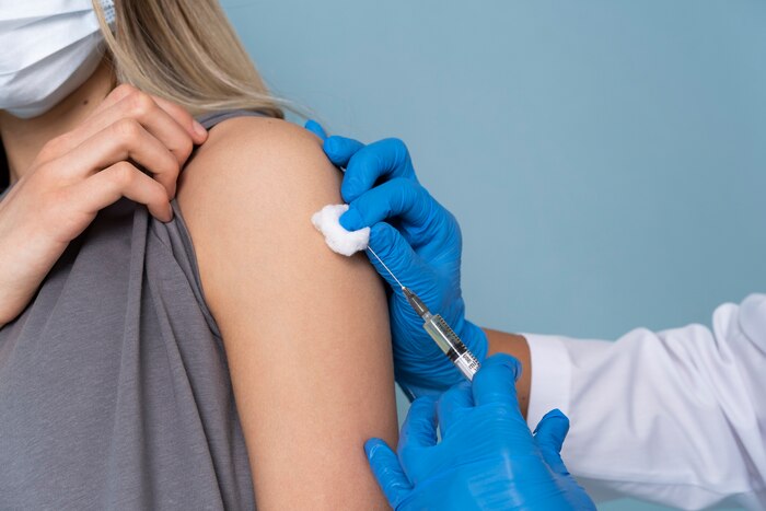 Female patient with medical mask getting a vaccine