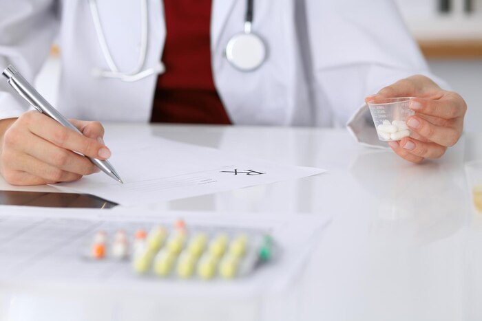 Female medicine doctor fills up  prescription form to patient closeup. panacea and life save, prescribe treatment, legal drug store, contraception concept