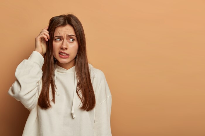 Well, maybe. confused beautiful young woman scratches head, feels uncertain while making decision, thinks what order to make, concentrated aside