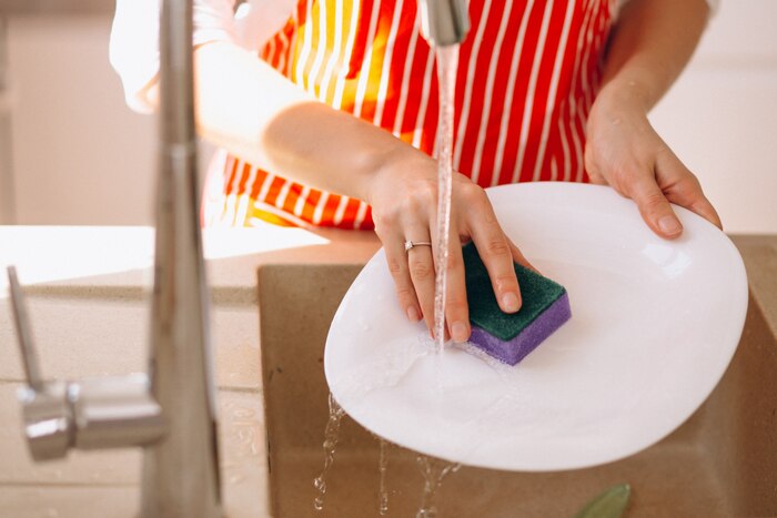 Female hands washing doshes close up