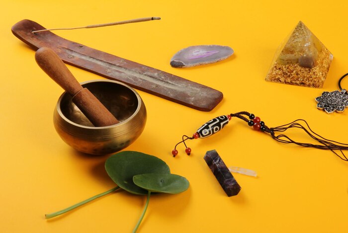 Tibetan dzi bead amulet necklace, tibetan singing bowl on a yellow background