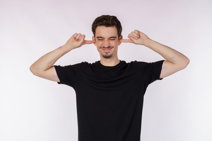 Portrait of attractive man close ears from noisy neighbours looking up and shouting annoyed hearing loud music on isolated background