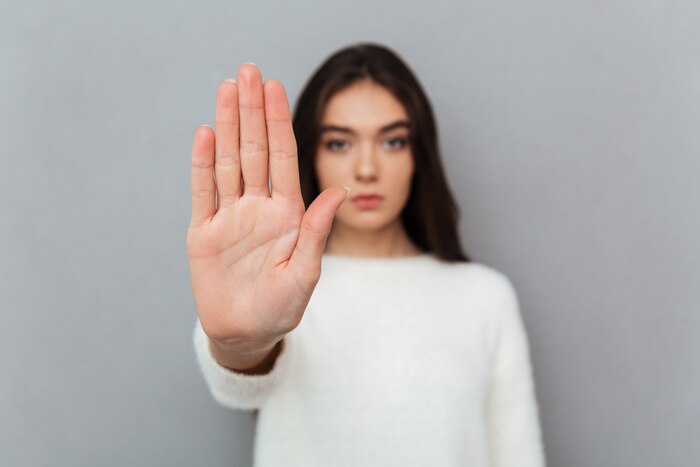 Close up portrait of a woman showing stop gesture